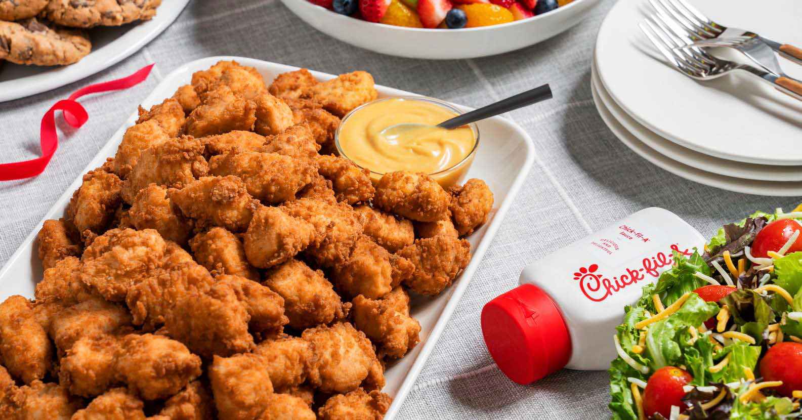 Chick-fil-A Nugget Tray with a bottle of Chick-fil-A Sauce and Garden Salad Tray.