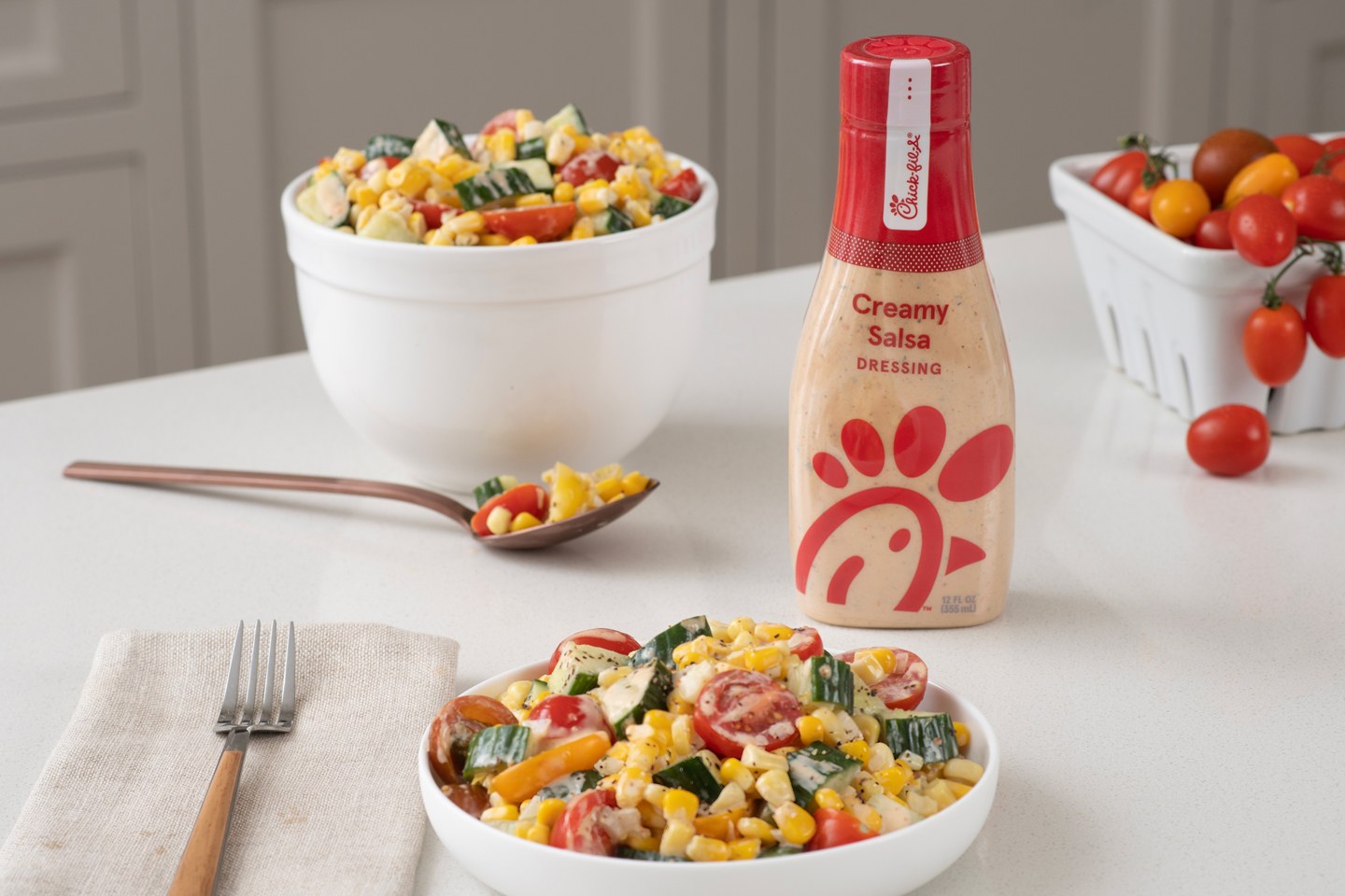 Southwest Creamy Salsa Corn Salad prepared in a bowl in front of a bottle of Creamy Salsa Dressing. 