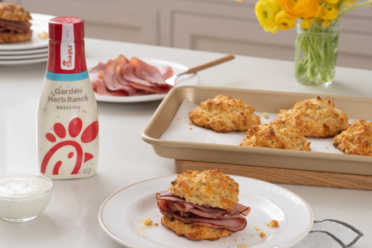 Cheddar Ranch Biscuits with Ham on a plate in front of a bottle of Garden Herb Ranch Dressing