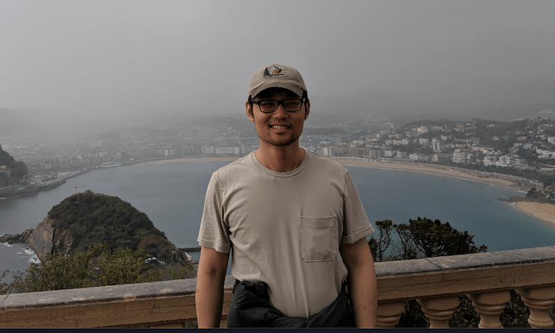 Yunha standing on a bridge above a body of water