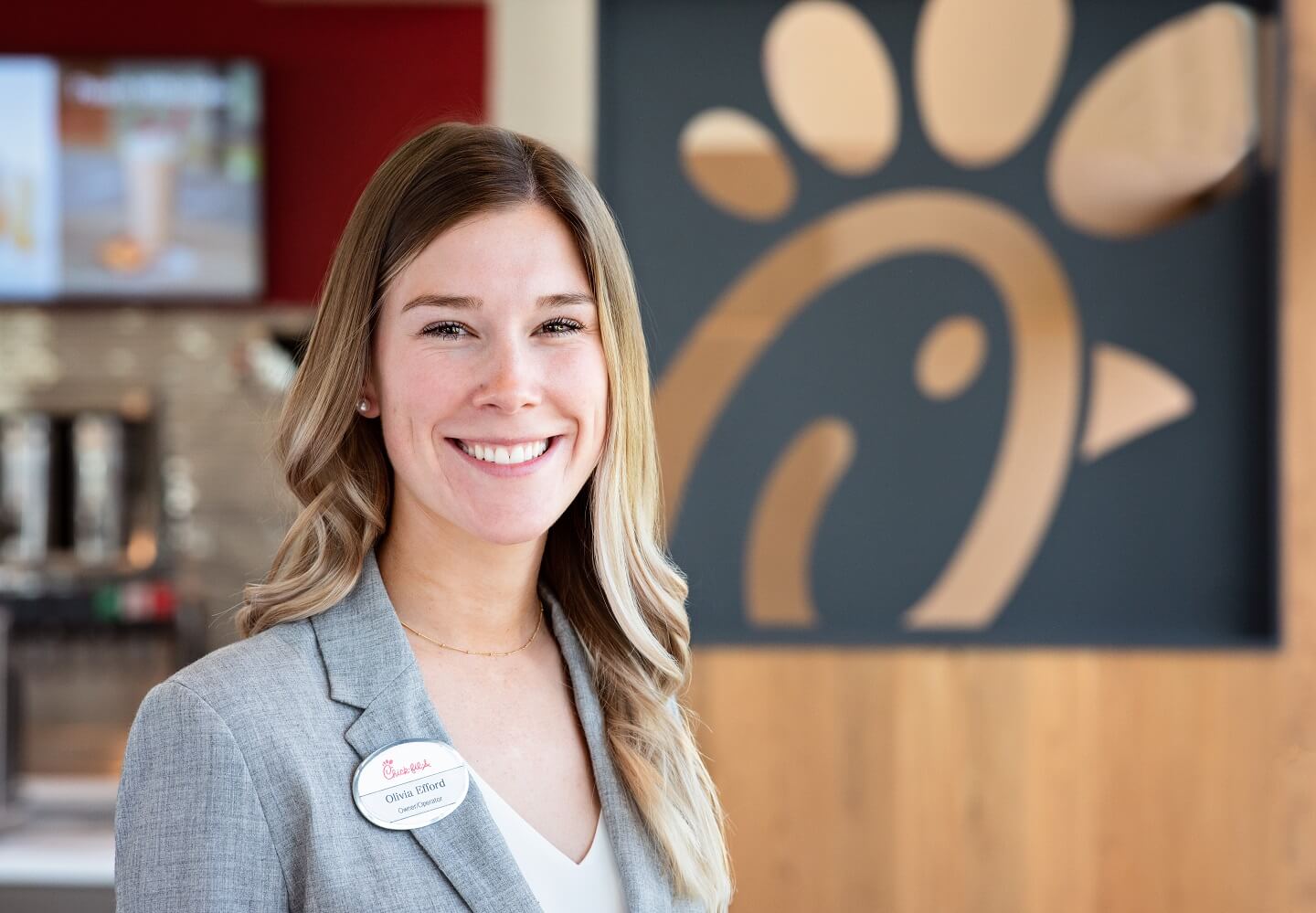 Headshot of Olivia Efford, smiling and standing inside restaurant