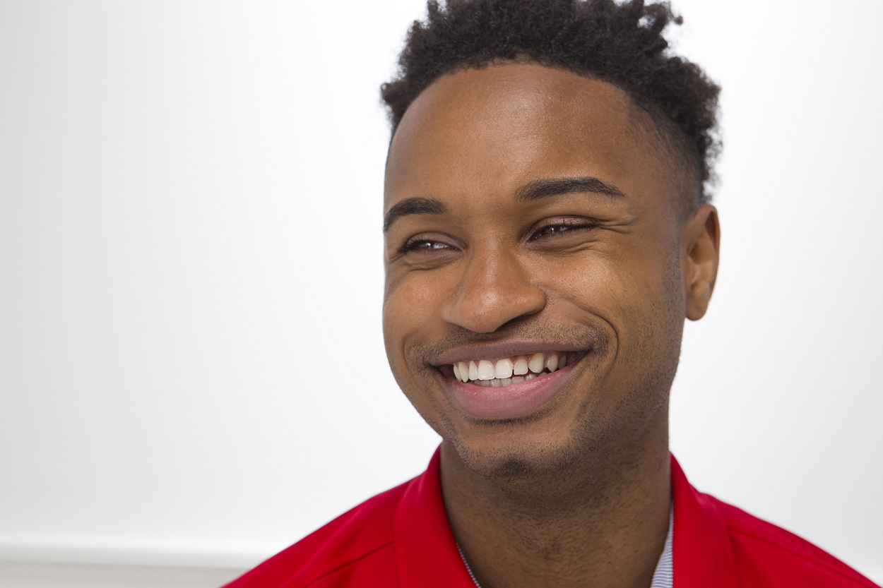 Headshot of smiling man in red shirt