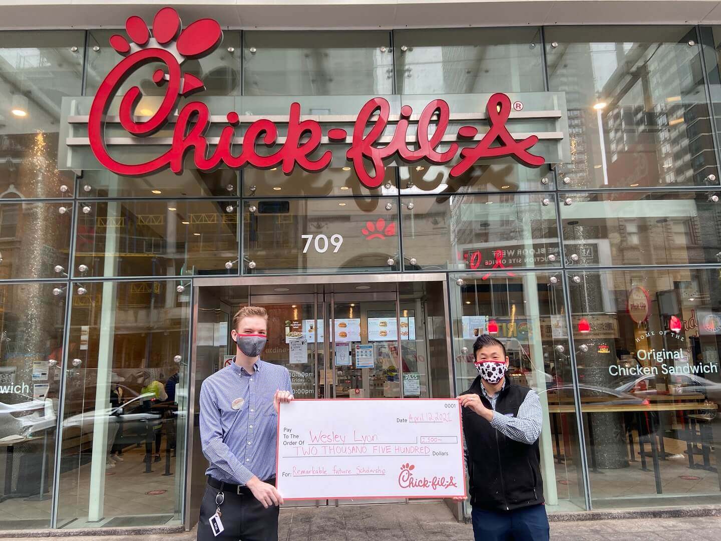 Two male Team Members holding check for Remarkable Futures Scholarship