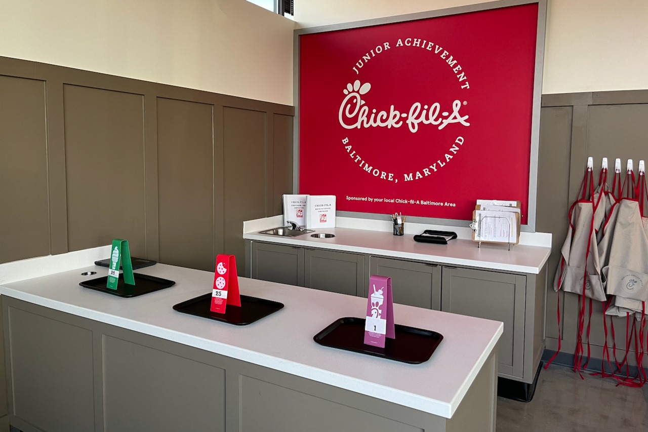 Inside of Junior Achievement Center with Chick-fil-A sign in background and counters with Chick-fil-A trays and small signage
