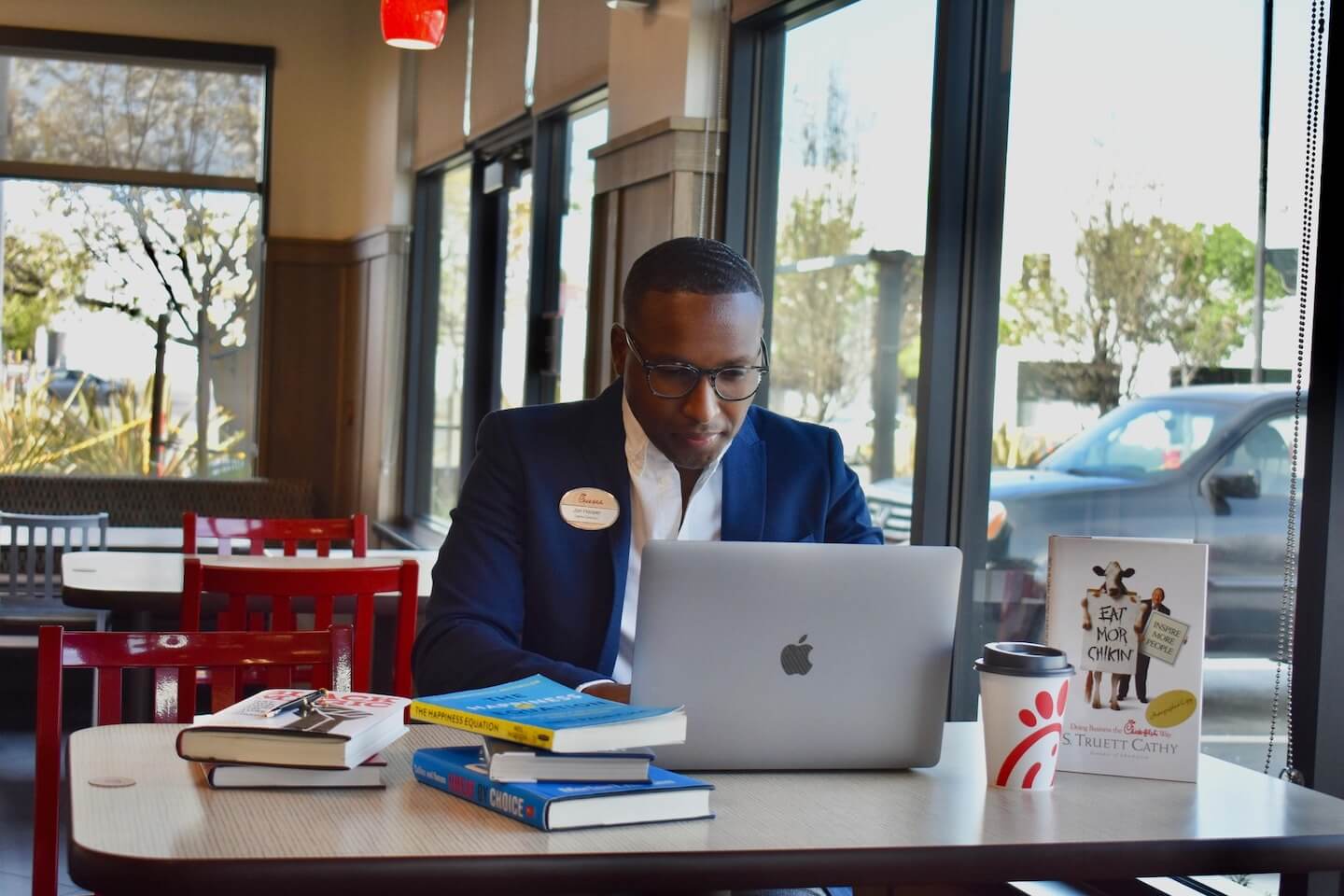 Owner/operator of Chick-fil-A Emeryville, Jon Hooper, types on his computer at a Chick-fil-A table in the restaurant
