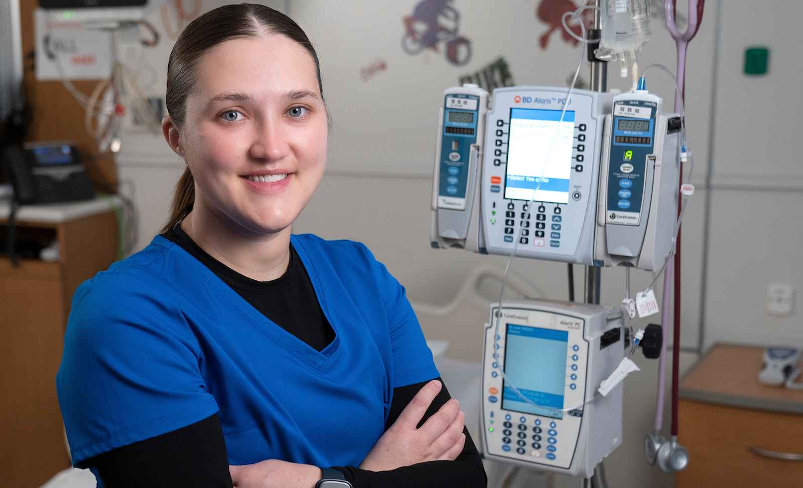 Skylar Lund at St. Jude’s Children Research Hospital in front of a medical device.