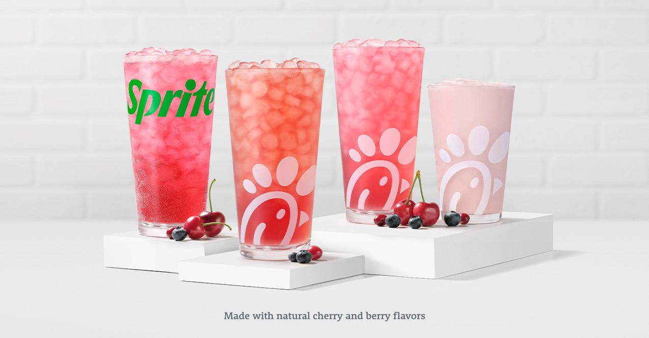 Glasses of Cherry Berry & Sprite®, Cherry Berry Sunjoy®, Cherry Berry Lemonade and Cherry Berry Frosted Lemonade sitting on white risers with cherries and berries sitting in front of them