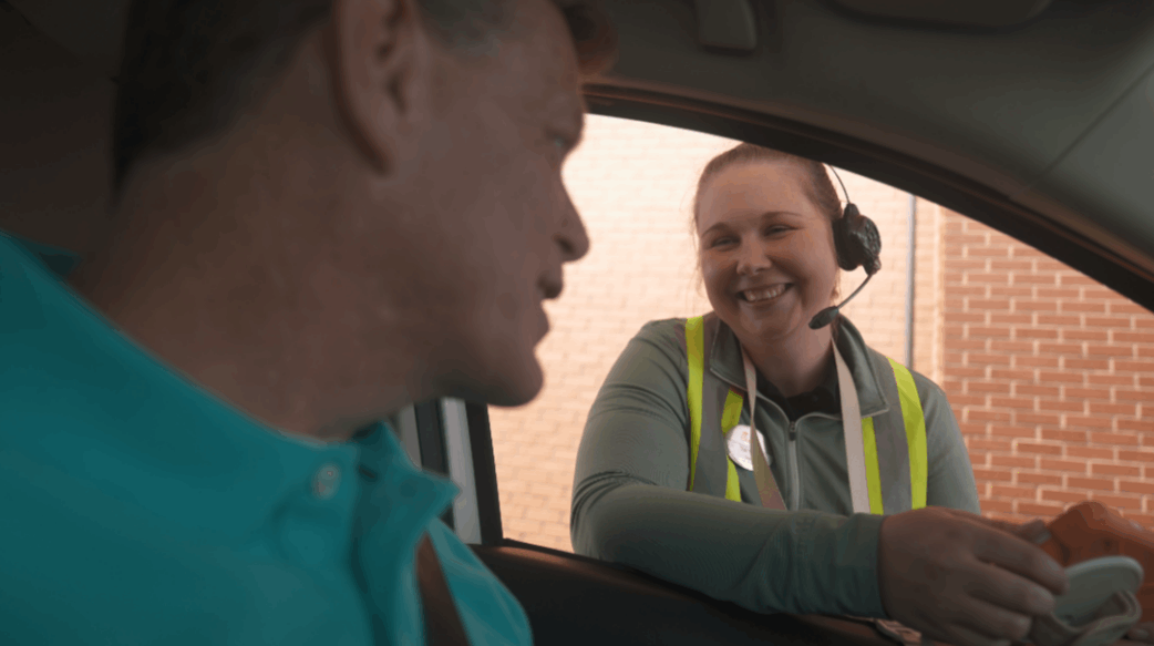 A Team Member talking to a customer who is sitting in his car