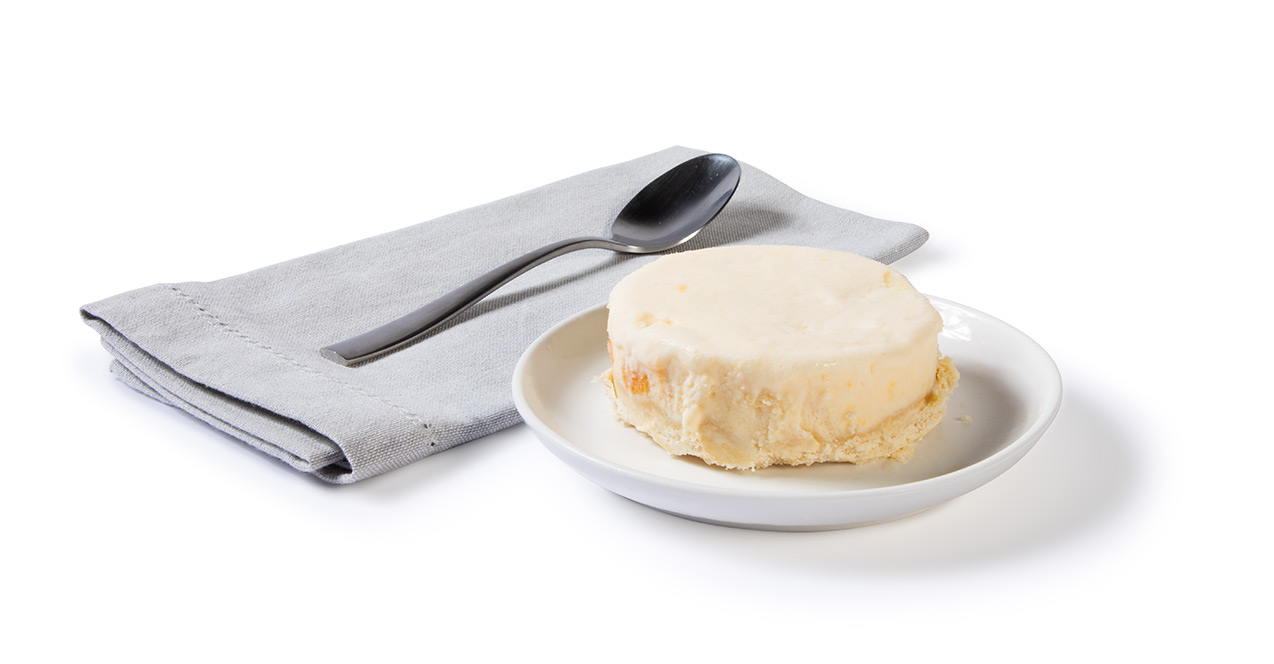 Icebox Peach Tart sitting on a white plate with a napkin and spoon next to it