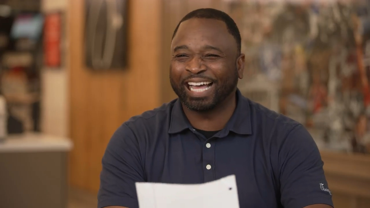 A person holding a piece of paper and smiling