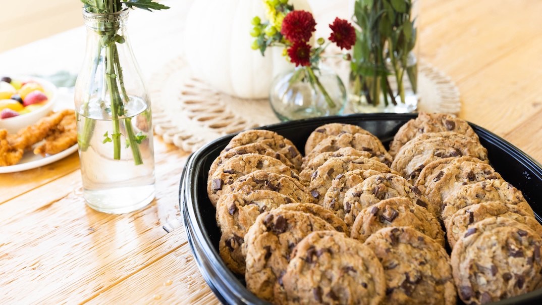 Chocolate Chunk Cookie Tray on a white with flower vases around it 