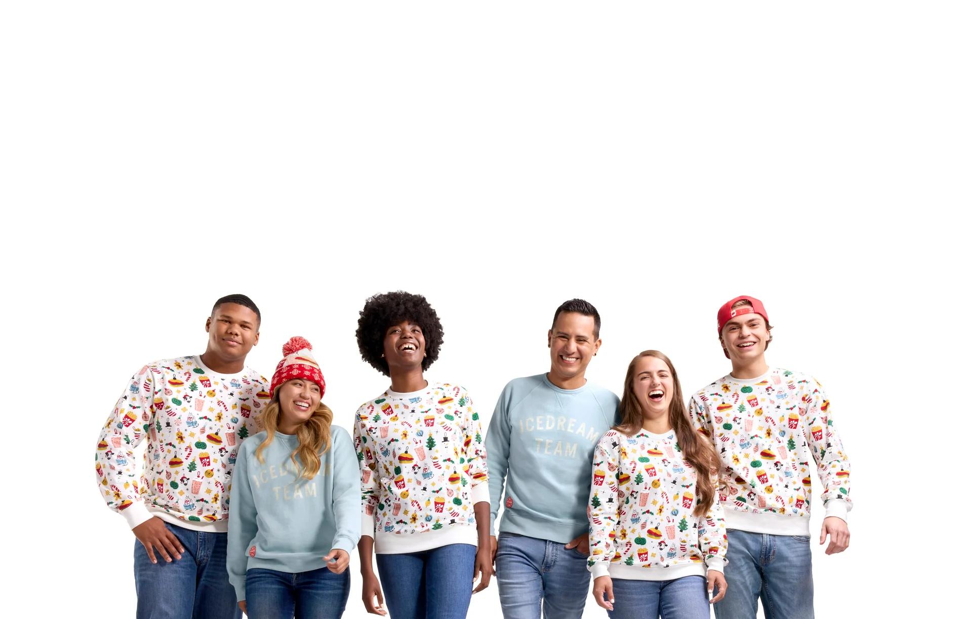 People standing together and wearing the Very Merry Adult Crewneck and the Icedream Team Crewneck from the Chick-fil-A® Originals Holiday Collection