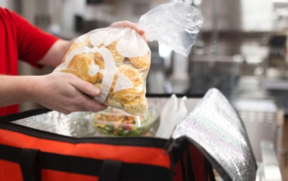 Chick-fil-A team member putting a bag of biscuits into a catering bag.