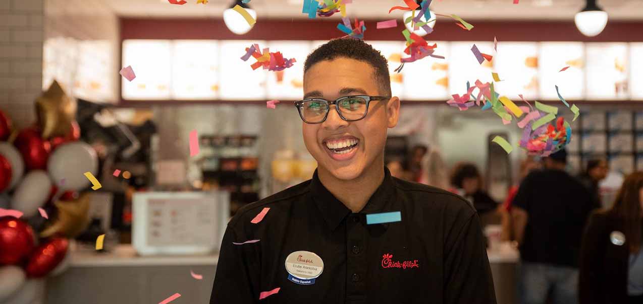A Chick-fil-A Team Member and scholarship recipient is celebrated with confetti. 