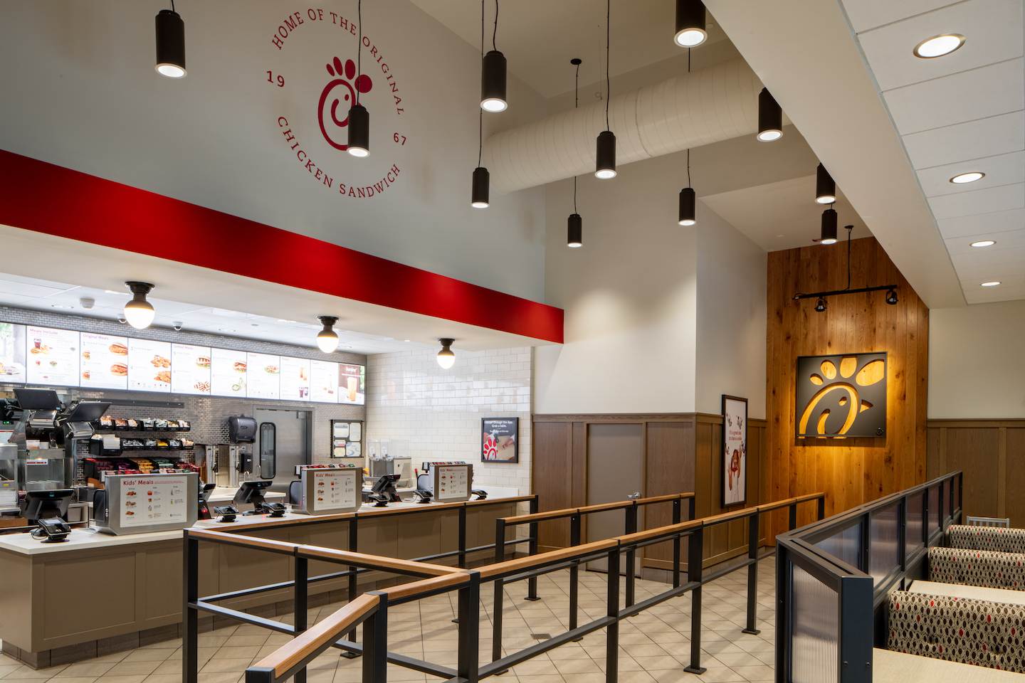 White interior of a Chick-fil-A with a brown wooden Chick-fil-A logo in the background.