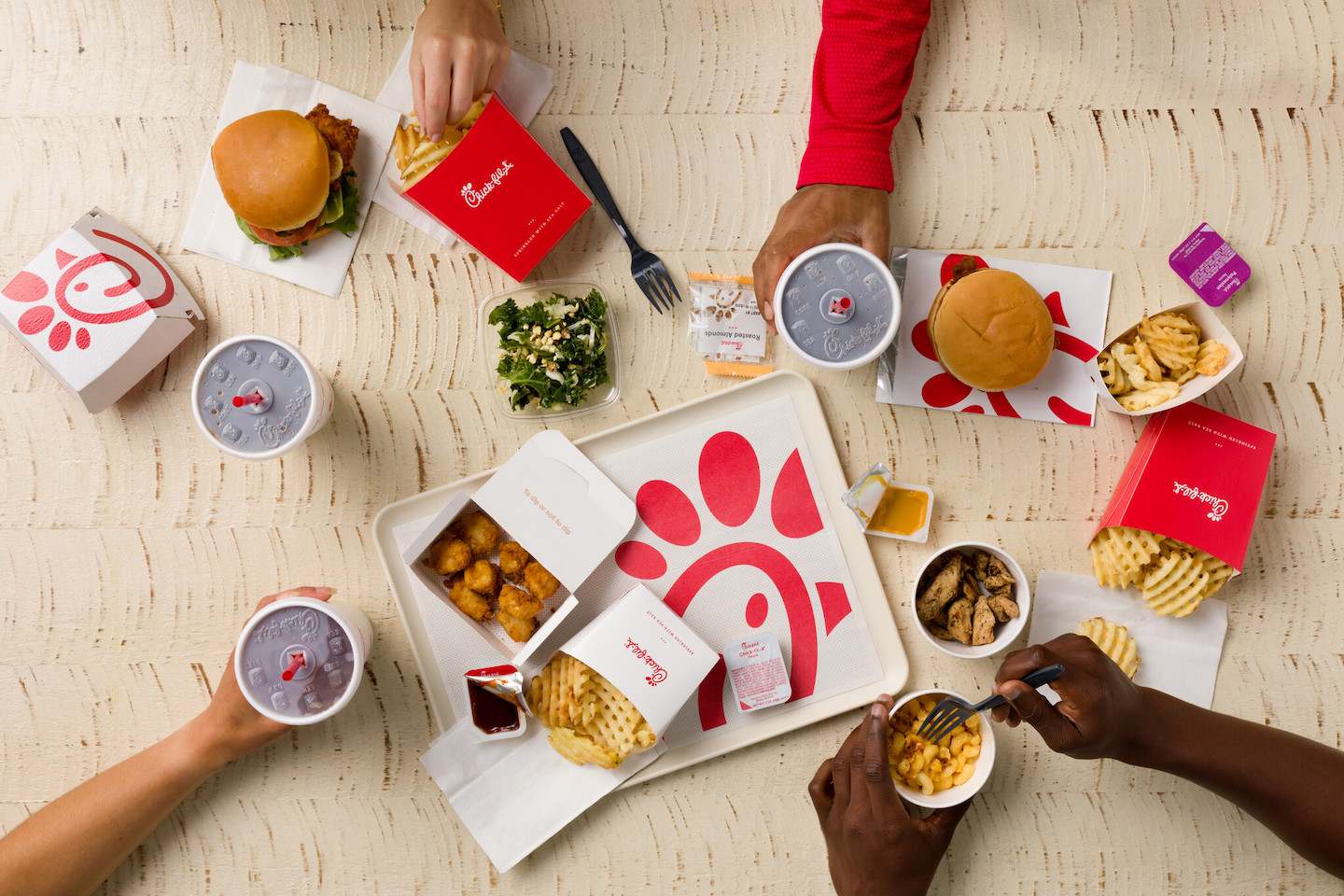 A spread of Chick-fil-A food, including Waffle Fries, beverages, Grilled Nuggets, Mac & Cheese, Nuggets and the original Chick-fil-A Chicken Sandwich.