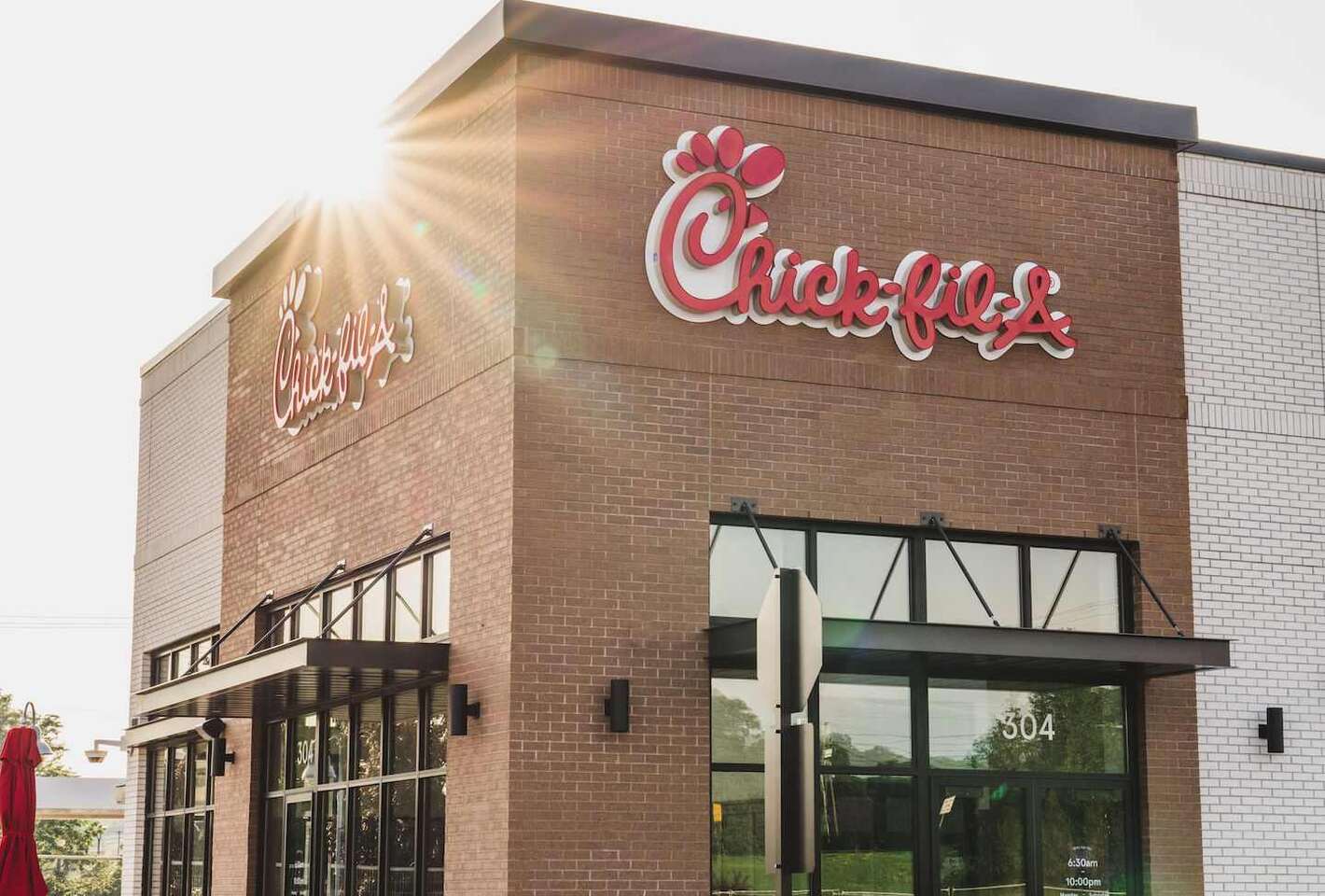 The exterior of a brick Chick-fil-A restaurant during the daytime.