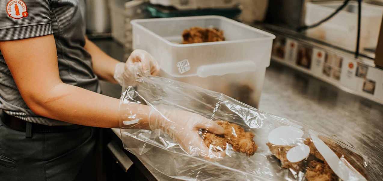 A Chick-fil-A Team Member packaging food through the Shared Table program. 