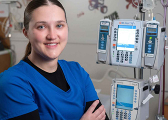 Skylar Lund at St. Jude’s Children Research Hospital in front of a medical device.