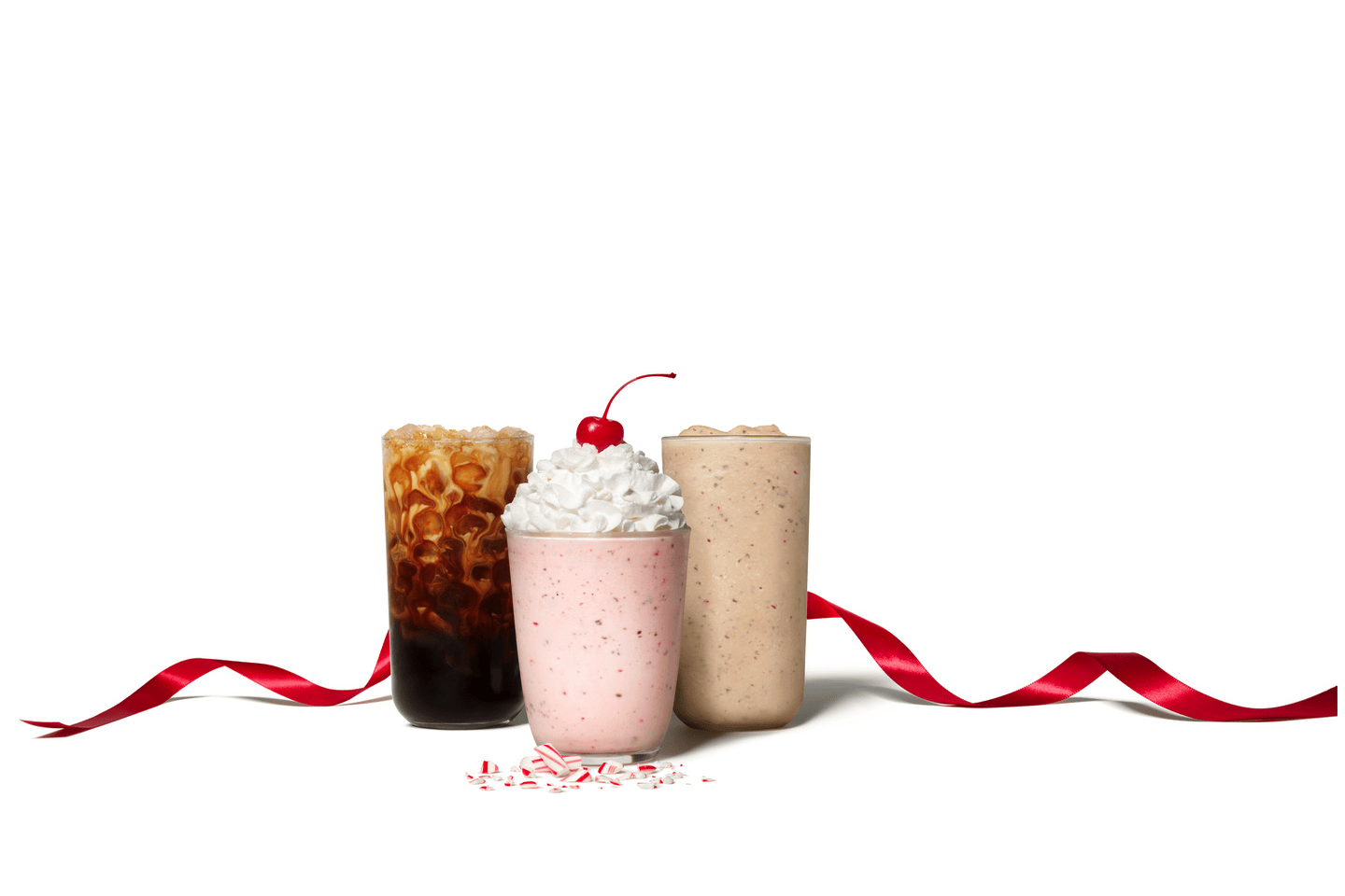 Three Chick-fil-A Peppermint Chip Beverages sitting on a white table with a red ribbon surrounding them.