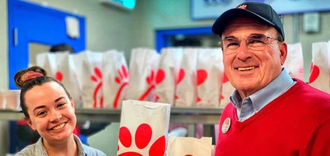 Chick-fil-A Operator Greg Patterson and a Team Member pose with bags of food that are being donated to the St. Vincent de Paul Society as part of the Chick-fil-A Shared Table program.