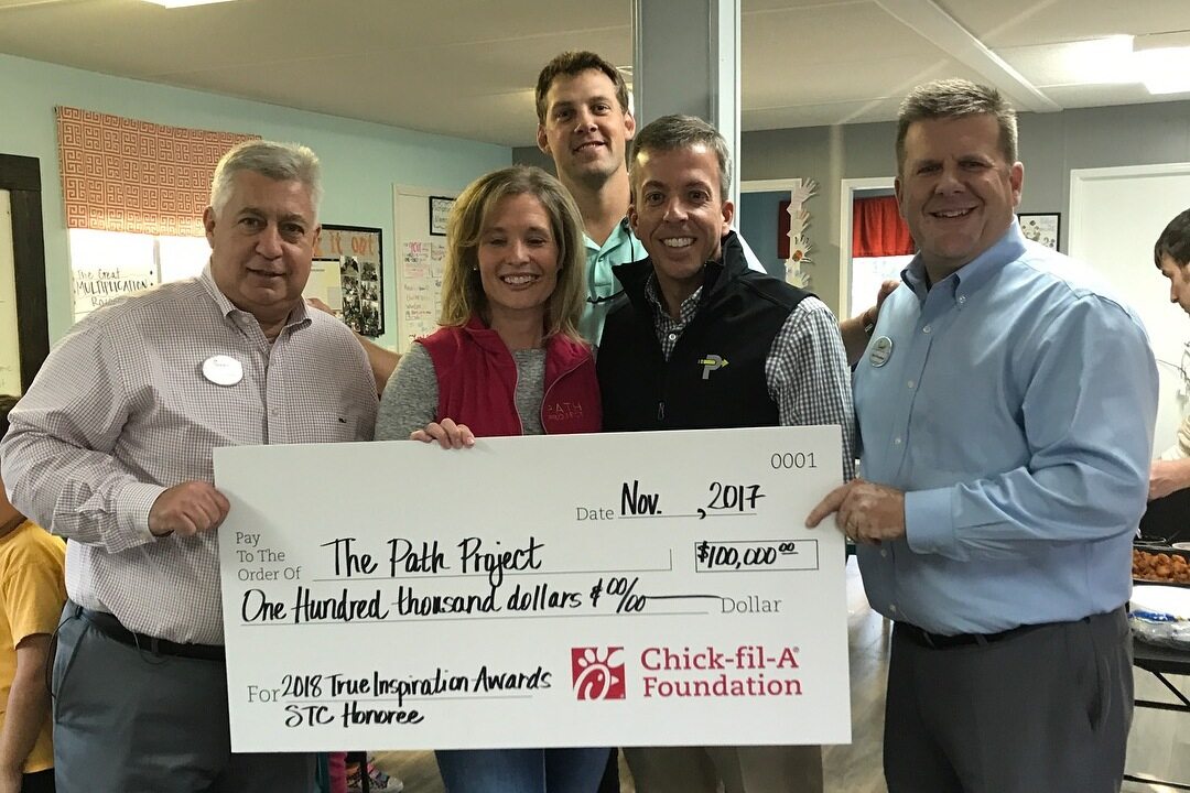 Chick-fil-A representatives handing a check to representatives from Path United in Monroe, GA.