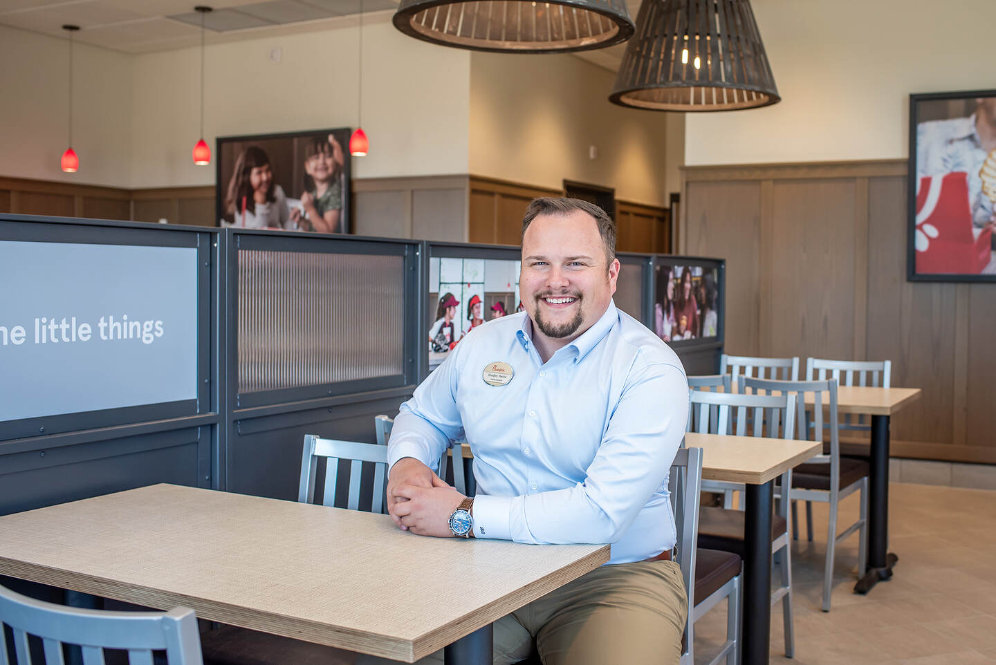 Chick-fil-A Orillia Owner-Operator Bradley Bache seated at a table inside his restaurant in the daytime.