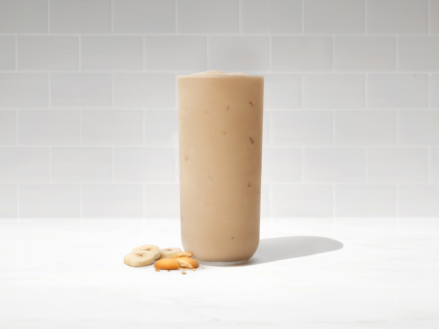 The new Banana Pudding Frosted Coffee from Chick-fil-A in a glass on a white countertop.