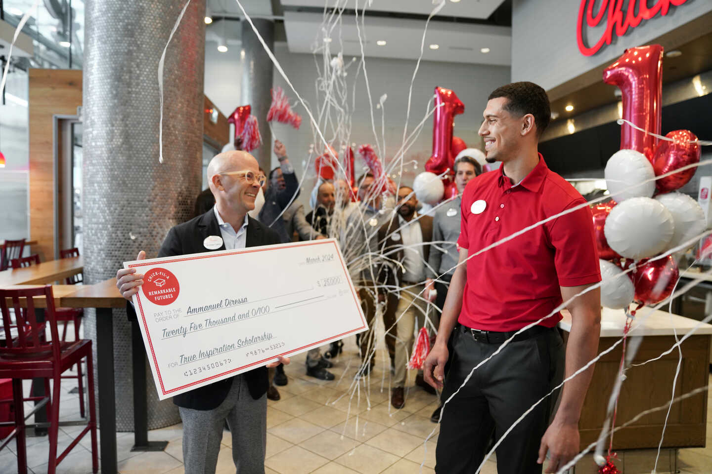 Chick-fil-A President Andrew Cathy handing a scholarship check to Ammanuel Diressa, the first Canadian True Inspiration Scholar.