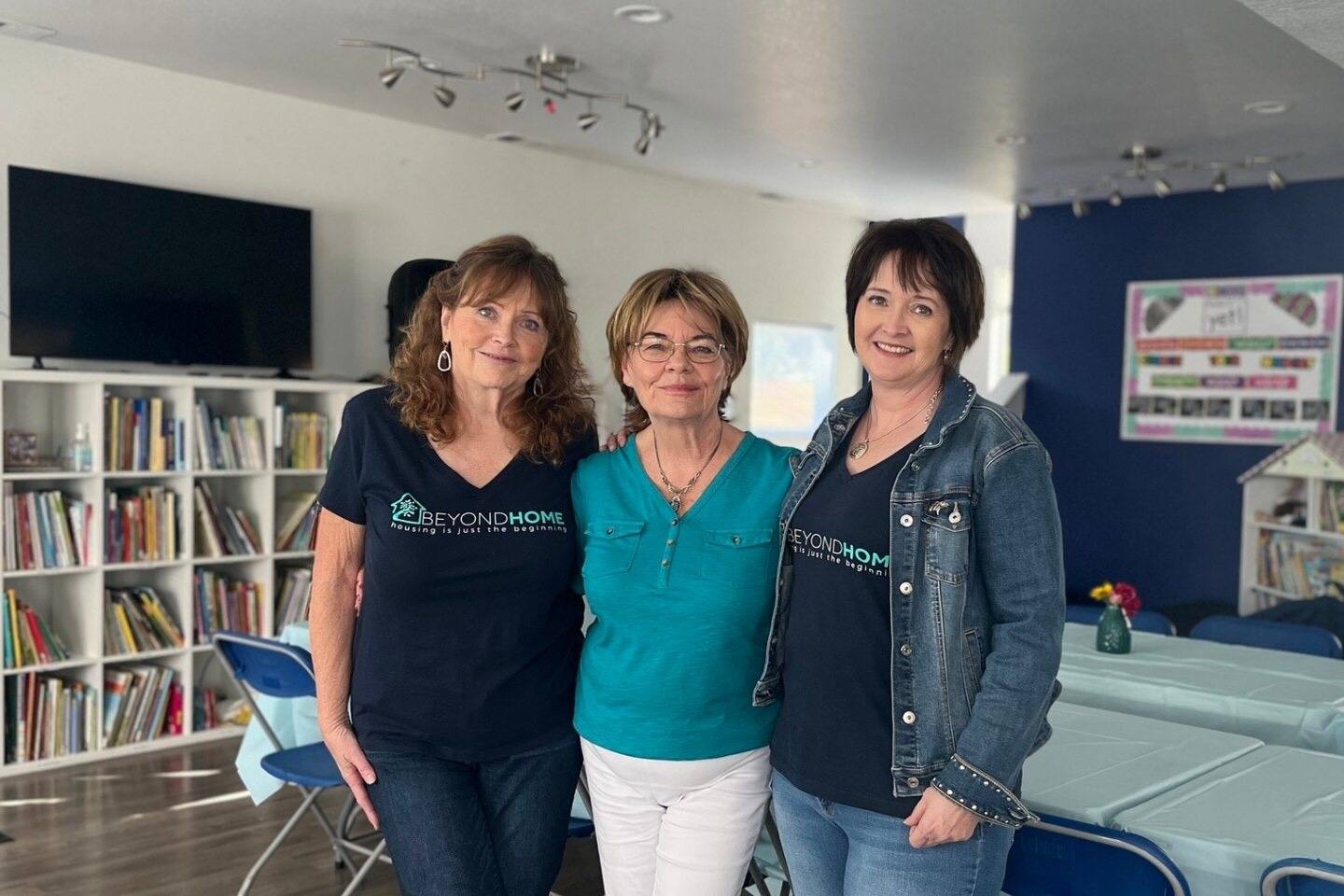 Three women from the BeyondHome nonprofit standing and smiling. 