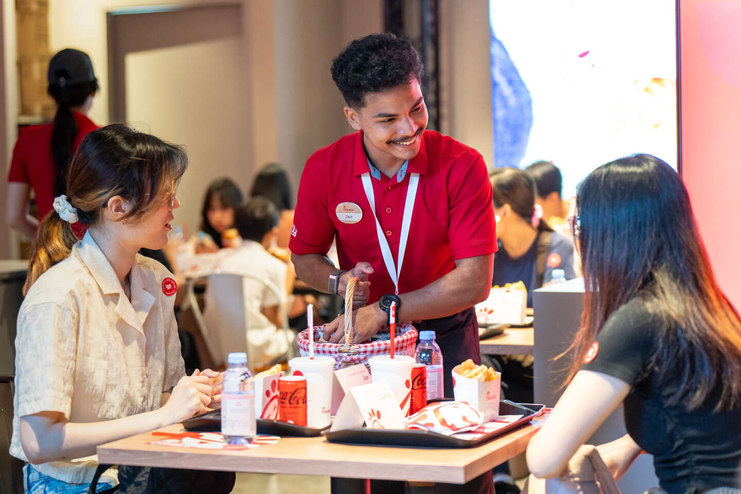 Two Guests being served by a Team Member at the Chick-fil-A pop-up event in Singapore.