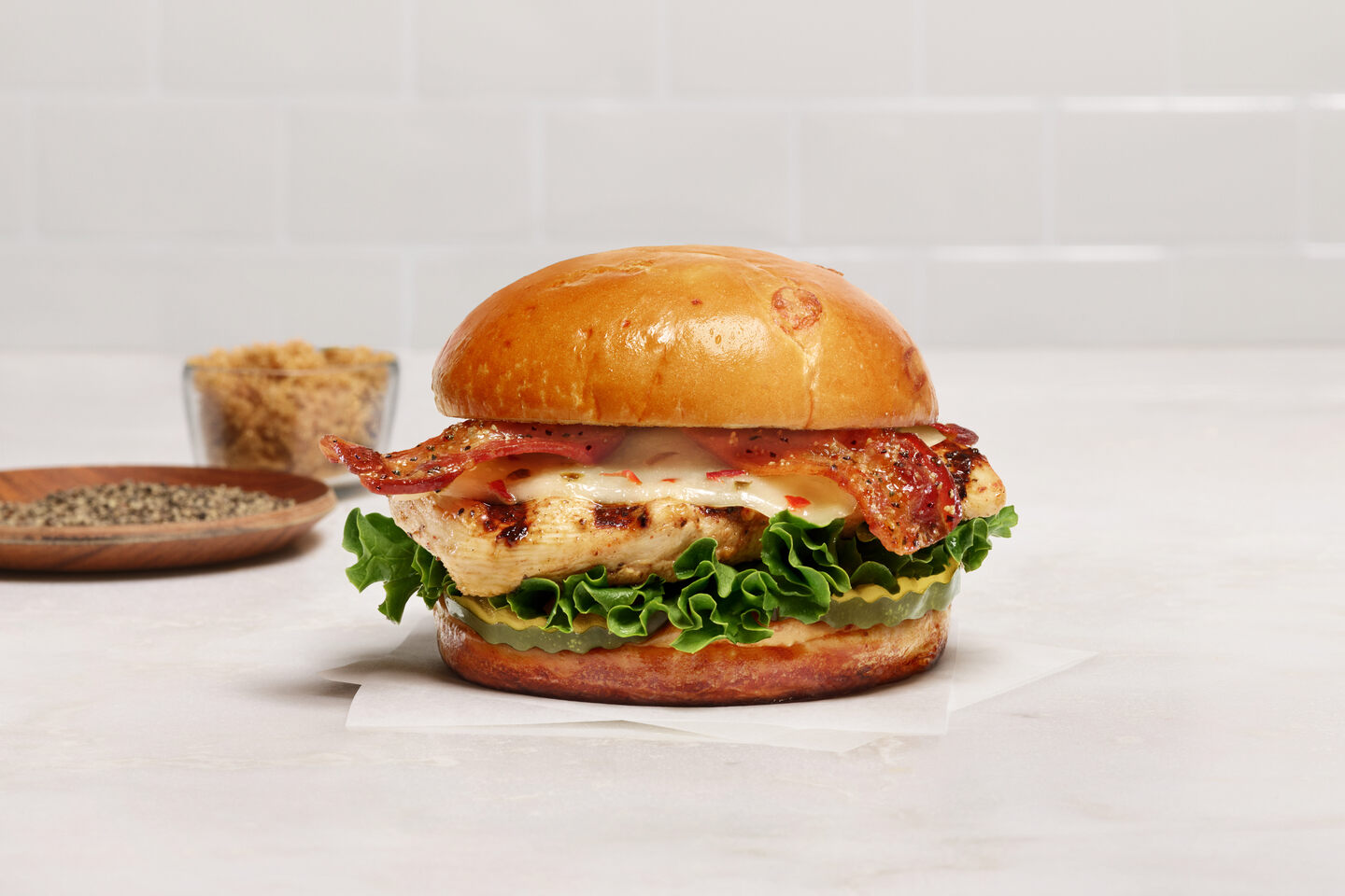 The new Chick-fil-A Maple Pepper Bacon Sandwich on a wooden countertop.