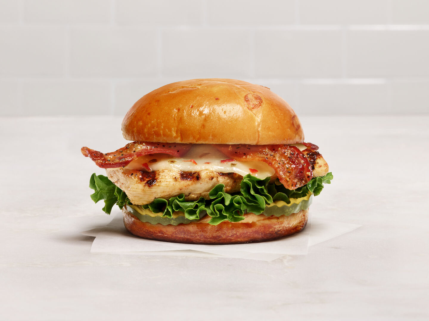 The new Chick-fil-A Maple Pepper Bacon Sandwich on a white countertop.
