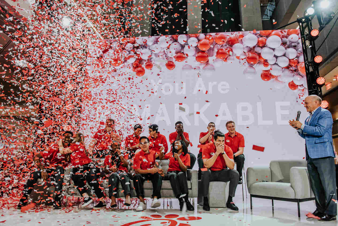 Confetti pours onto a group of True Inspiration Scholars as they are acknowledged on a stage.