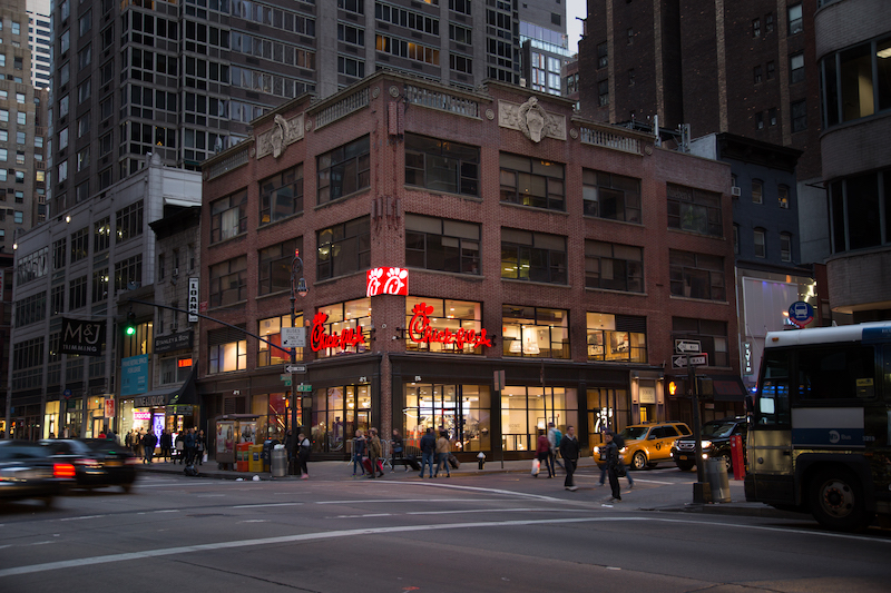 A Chick-fil-A on a street corner in a city.