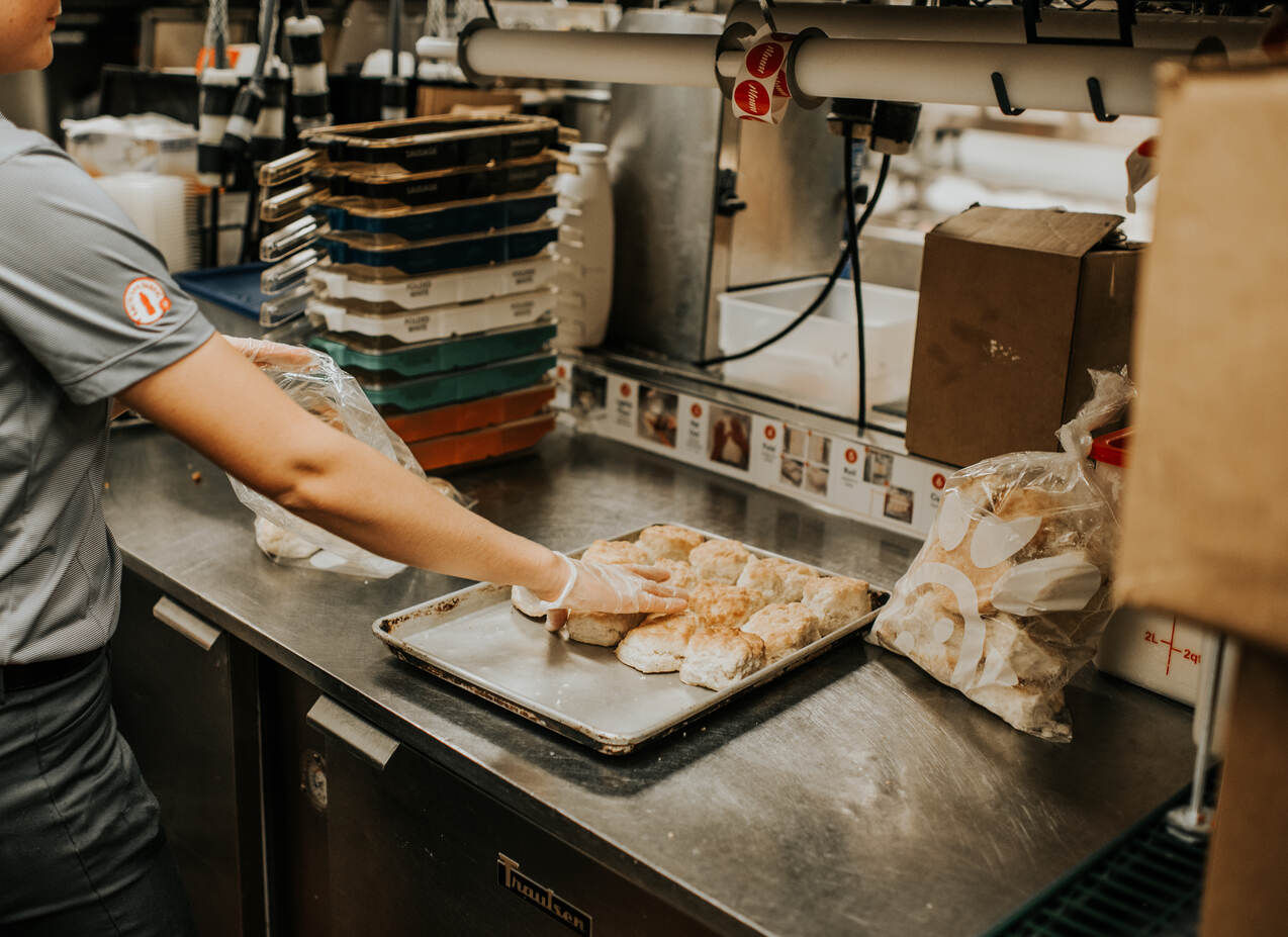 Team Member placing Chick-fil-A Biscuits on pan.