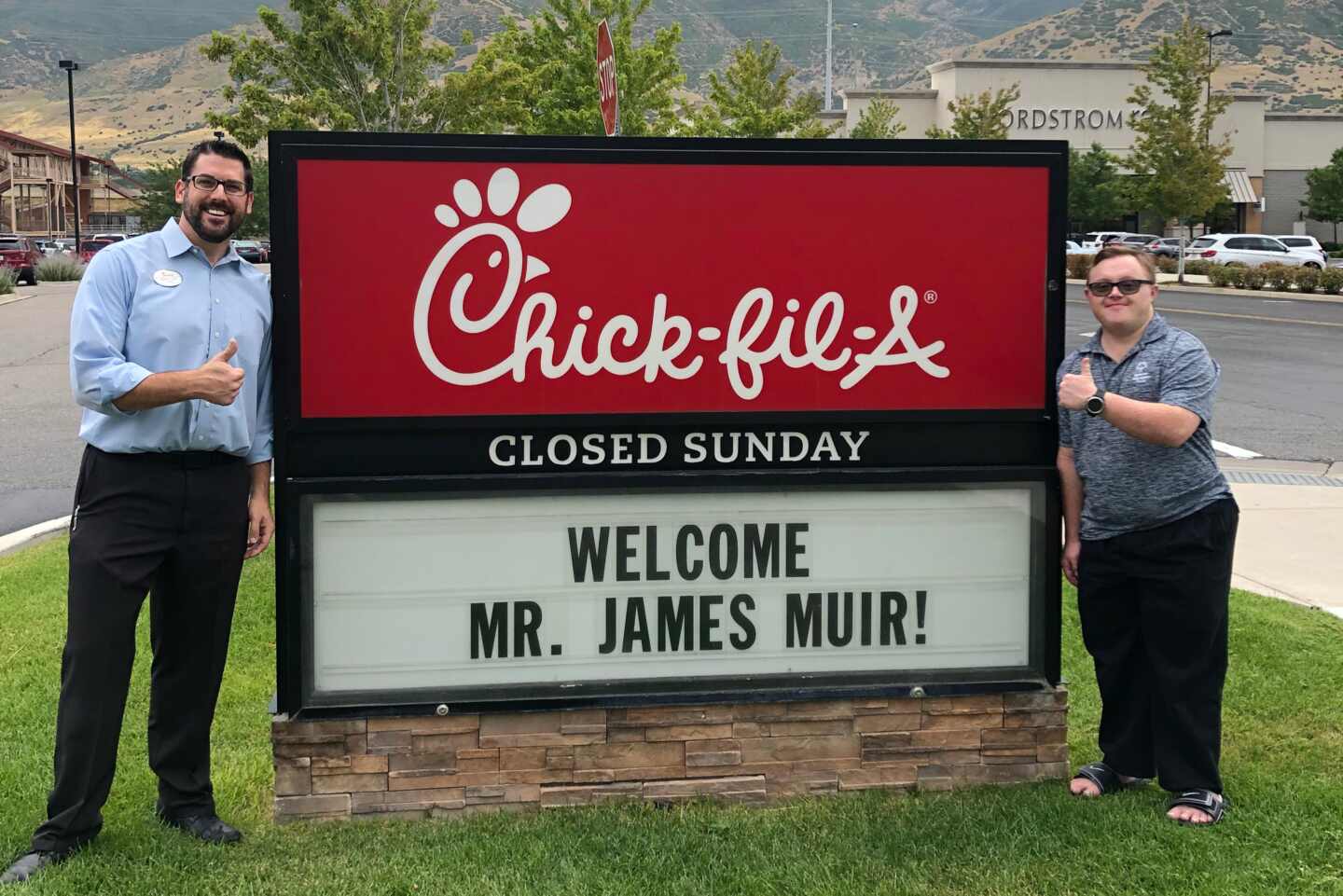 Chick-fil-A Team Member James Muir standing alongside his local Owner-Operator in Melbourne, Fla.