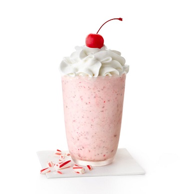 Peppermint Chip Milkshake in a glass with whipped cream and a cherry