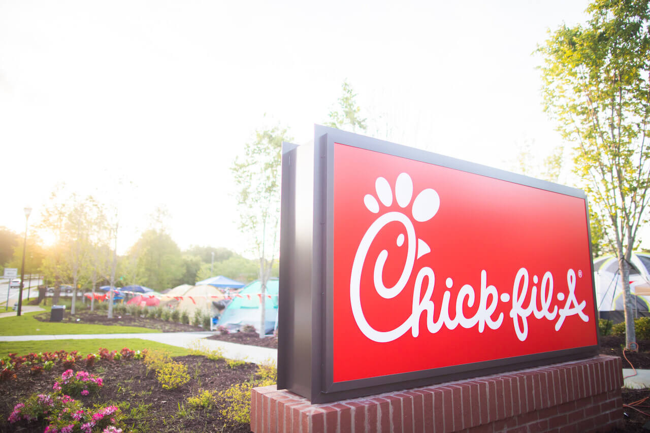 Large outdoor Chick-fil-A® Restaurant sign with landscaping in the background