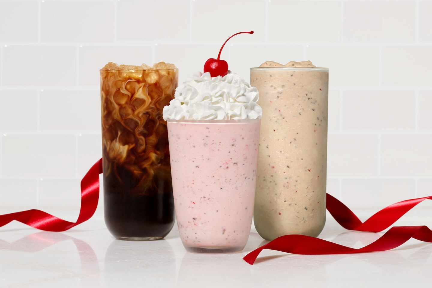 Three Chick-fil-A Peppermint beverages on a counter with a red ribbon 