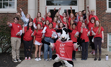 Group of students standing outside with a Chick-fil-A® cow