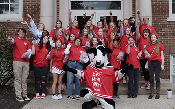 Group of students standing outside with a Chick-fil-A® cow