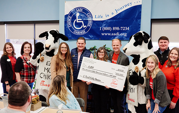 Nonprofit recipient of True Inspiration Award® standing in a group, holding large check