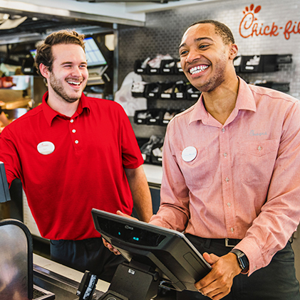 Seated Team Member smiling while talking to another person