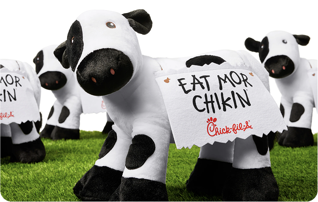 Rows of plush Chick-fil-A Cows with signs on them that say “Eat Mor Chikin”