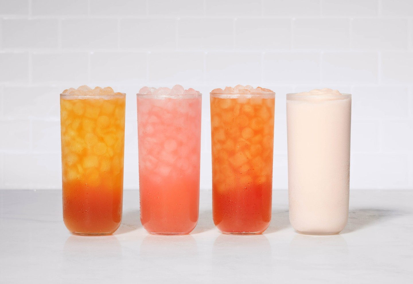 A Watermelon Mint Sunjoy, a Watermelon Mint Lemonade, A Watermelon Mint Iced Tea and a Watermelon Mint Frosted Lemonade are positioned side by side in glasses. 