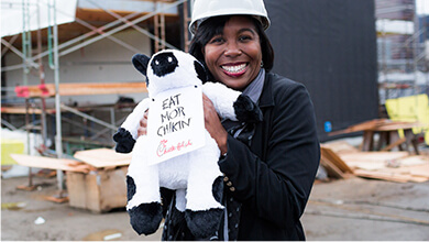 A person standing outside and holding a plush Chick-fil-A® Cow