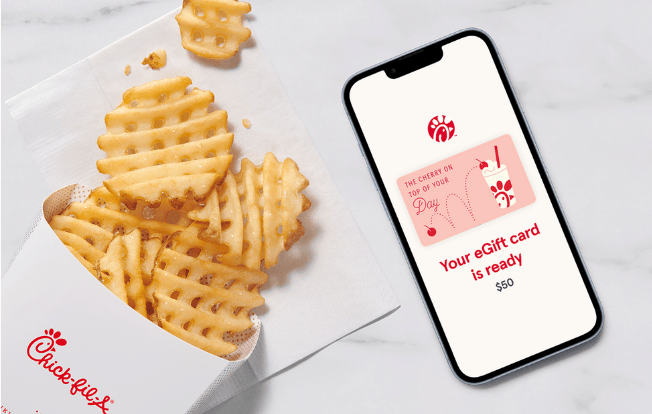 A smartphone with a Chick-fil-A® eGift card on the screen that says "The cherry on to of your day" sitting next to Waffle Fries