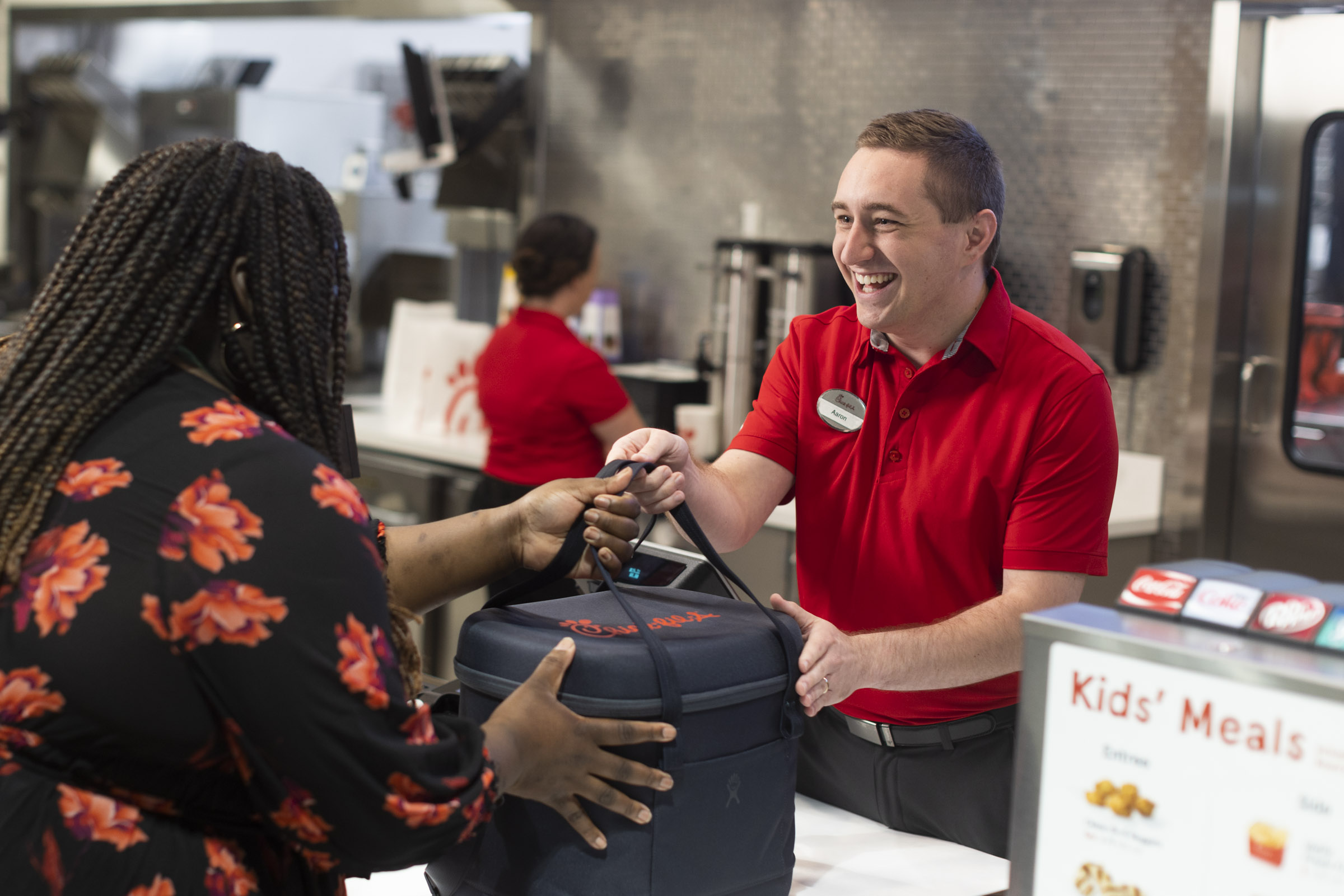 A Team Member handing a customer an insulated Chick-fil-A bag