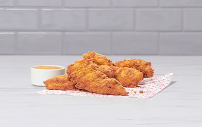 Chick-fil-A Chick-n-Strips on printed parchment paper with dipping sauce